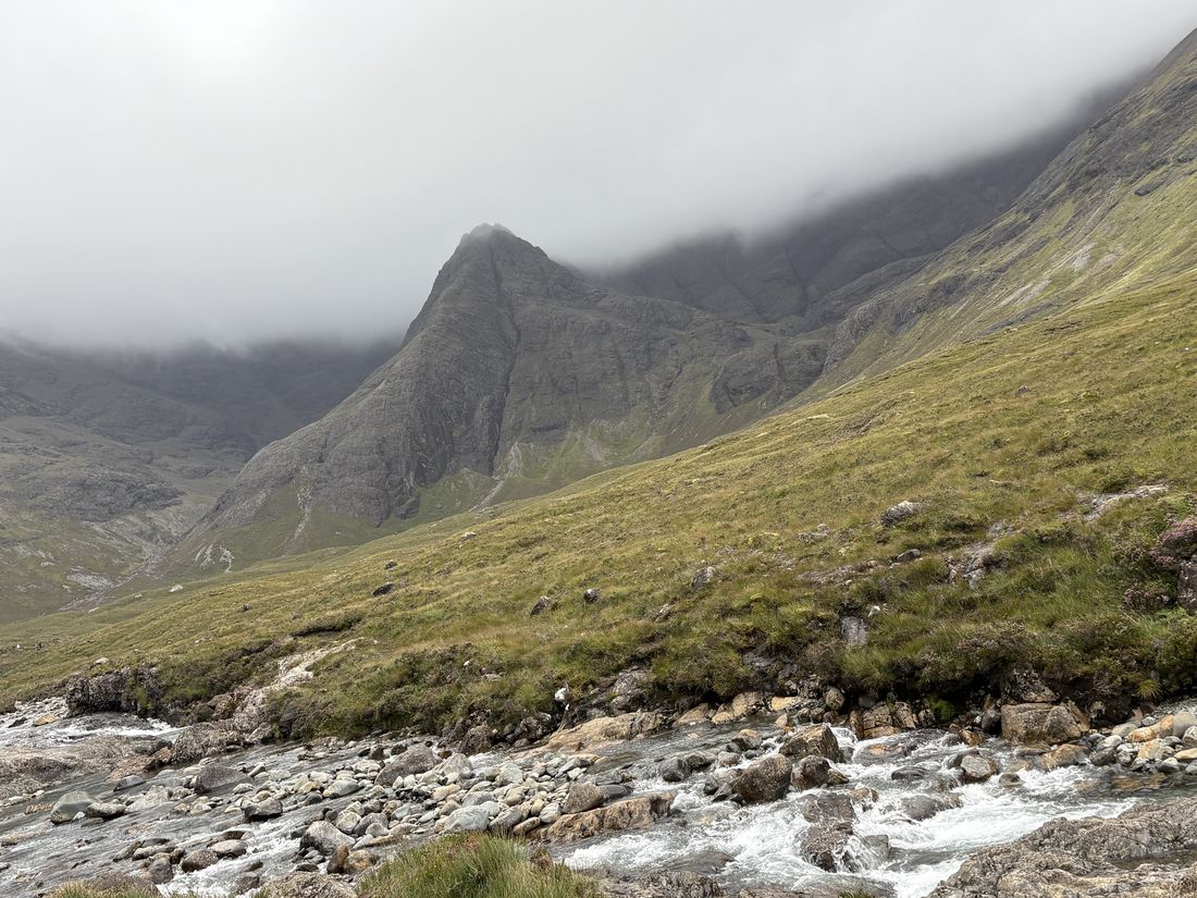 Paisaje de montaña con niebla y riachuelo en la isla de Skye, Escocia